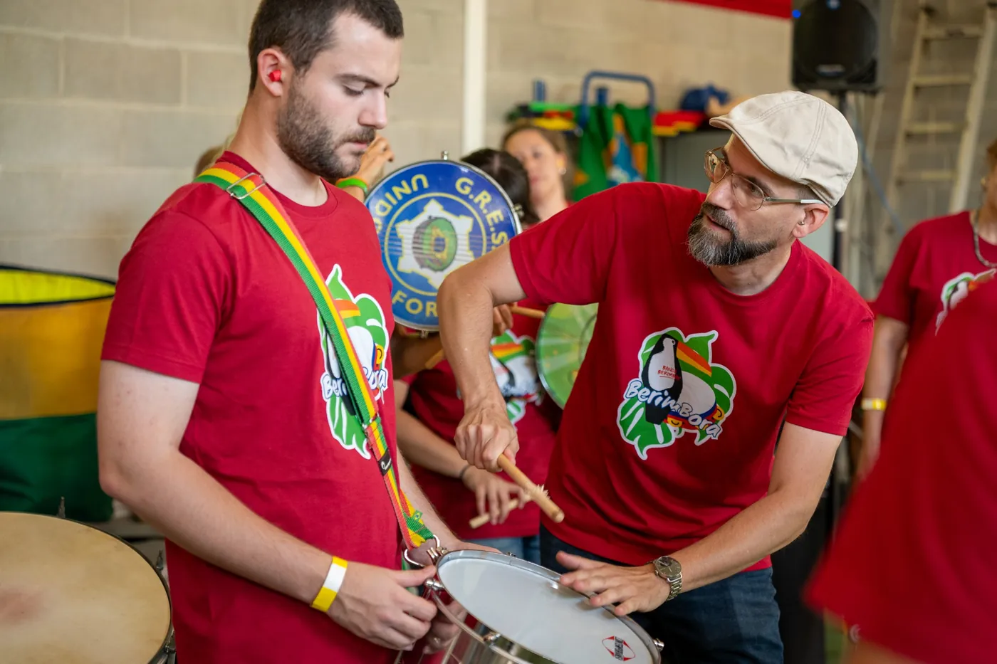 Chris leaning towards a samba drummer to demonstrate an instrument technique
