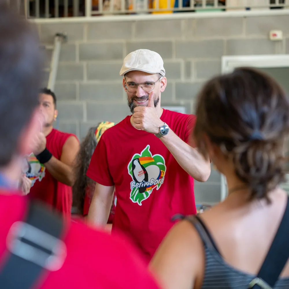 Chris smiling and giving a thumbs-up to participants during a samba workshop